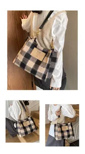 Detail of plaid tote bag featuring a leather bear patch and gold chain shoulder strap