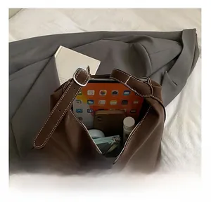 Detail view of the large capacity interior of this brown faux suede tote bag