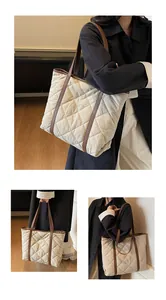 Detail of beige quilted tote bag showing brown leather handles and spacious interior