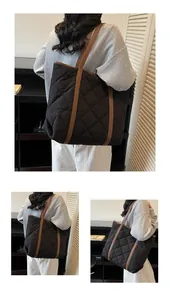 Close-up of black quilted tote bag featuring brown straps and spacious interior detail