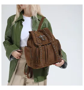 Close-up of brown suede tote backpack featuring metal rivets and cross pendant detail