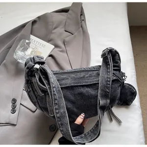 Detail of grey denim crescent bag with washed finish and matching mini coin purse