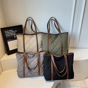 Quilted tote bags in white, olive, gray, and black with leather shoulder straps
