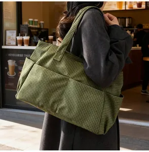 Détail du grand sac cabas en toile à carreaux verts avec poches pour le quotidien