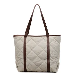 Quilted off-white tote bag with brown leather handles and spacious interior design