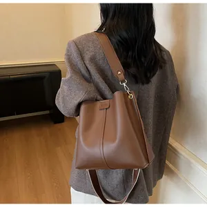 Vue arrière du sac seau en cuir marron montrant les coutures et la quincaillerie dorée
