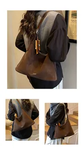 Detail of dark brown faux suede tote bag featuring retro wooden beads and minimalist logo