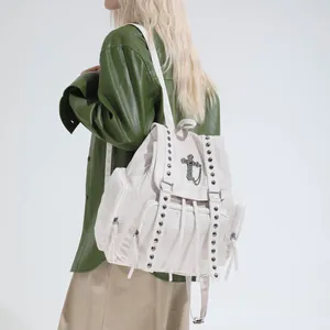 White retro rivet tote backpack with cross pendant and multi-pocket detail on model