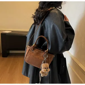 Details der Vintage-Tasche mit Leopardenmuster, Plüschanhänger und metallischen Ösen