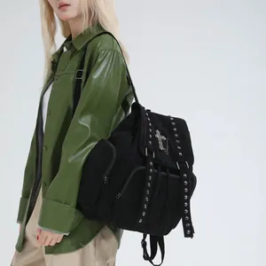 Gothic black rivet backpack with silver cross pendant shown on model in studio view