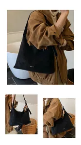 Detail of black suede tote bag with colorful wooden bead tassel and side brand logo