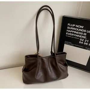 Gros plan d'un sac cabas en similicuir marron foncé avec de longues doubles bandoulières