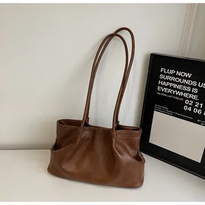 Gros plan sur la texture plissée d'un grand sac cabas en cuir marron pour femme