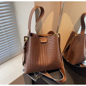 Détails d'un sac cabas tissé marron avec bandoulières interchangeables en cuir