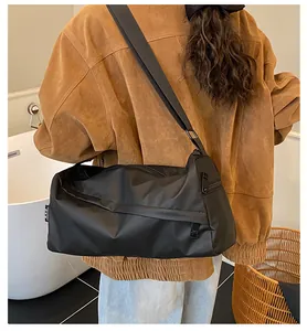 Vue latérale du grand sac à bandoulière noir en tissu Oxford imperméable porté par un mannequin