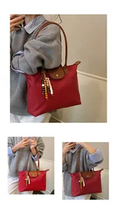Détails du sac fourre-tout rouge en nylon avec poignées en cuir et pendentif