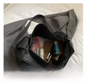 Détail montrant l'intérieur grande capacité du sac en nylon noir avec compartiments