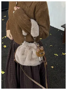 Detail of plush bucket bag with faux fur handle and brown leather shoulder strap