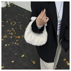Close-up of fluffy white faux fur handbag with soft pleated texture in autumn setting