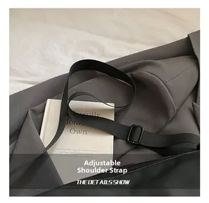 Détail de la bandoulière réglable en nylon noir sur un grand sac à bandoulière chic
