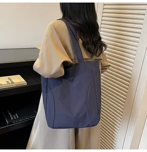 Detail of Medonle navy canvas tote bag showing the side view and strap on model