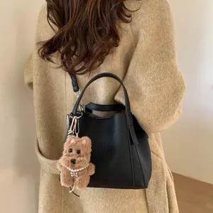 Retro large capacity black bucket bag with plush dog charm and model in wool coat