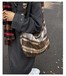 Plaid hobo tote bag in brown and white styled with a winter coat and scarf