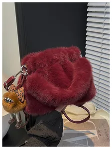 Detail of burgundy faux fur shoulder bag with cute plush bear pendant and silver hardware
