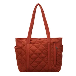 Orange quilted puffer tote bag with large capacity and shoulder straps for casual use