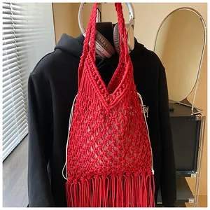 Detail van de rode handgemaakte macramé tas met lange franjes en witte koord binnentas