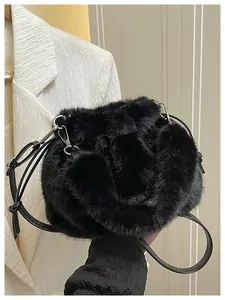 Detail of black faux fur drawstring bucket bag with silver metal buckle and sleek strap