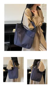 Close-up of a navy canvas tote bag featuring an embossed logo and high-density texture