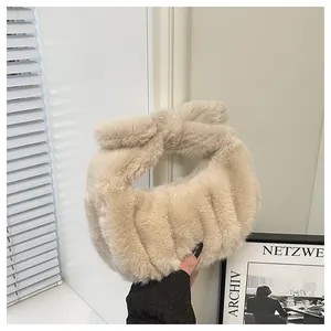 Detail of soft beige plush handbag with pleated texture and stylish bow handle