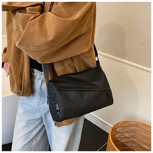 Détail de la bandoulière noire en nylon oxford portée avec une tenue décontractée