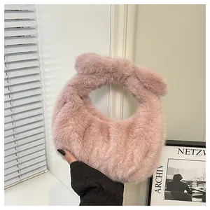 Detail of soft pink faux fur handbag with knotted handle design and plush texture