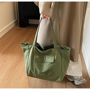 Nahaufnahme der grünen karierten Tragetasche mit Vordertasche von einem Model gehalten