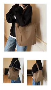 Detailed embroidery on khaki canvas tote bag with wide shoulder strap design