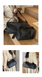 Gros plan du sac en tissu Oxford noir montrant la texture mate et la bandoulière réglable