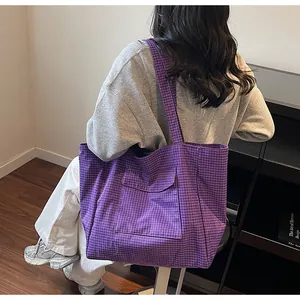 Detailansicht einer lila karierten Nylon-Tragetasche mit praktischer Klapptasche vorne