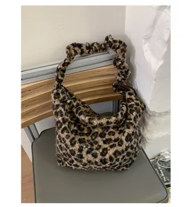 Detail of plush leopard print shoulder bag featuring a stylish scrunchie strap design