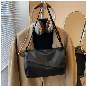 Vue détaillée du tissu en nylon noir haute densité et de l'étiquette tissée du sac bandoulière