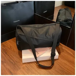 Détail du sac polochon en nylon imperméable avec bandoulière et étiquette tissée