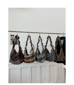 Detail view of various plaid and leopard print hobo bags with gathered cloud straps
