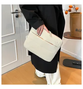 Nahaufnahme der cremefarbenen gesteppten Laptoptasche mit weicher Polsterstruktur