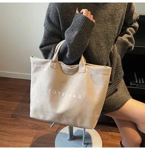 Close-up of cream large tote bag with TOTE BAG lettering and soft suede texture