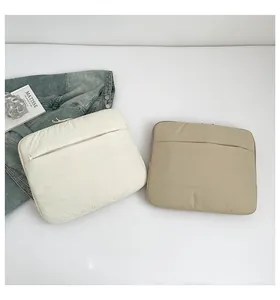 Close-up of quilted laptop sleeves in beige and khaki with protective zipper pockets