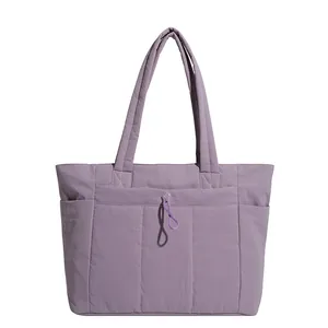 Large purple quilted down tote bag with front drawstring pocket and side compartments