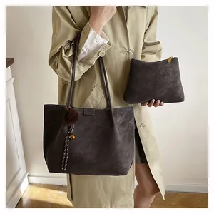 Brown vintage tote bag set with pom-pom charm and small pouch shown on a model