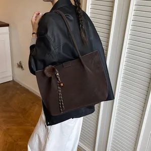Minimalist vintage tote bag in dark coffee brown with decorative pom-pom pendant