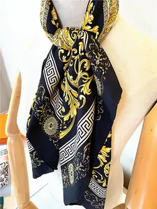 Detail of premium black silk-satin scarf featuring golden baroque floral and sun patterns